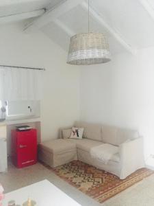 uma sala de estar branca com um sofá e um lustre em LOFRUs PLACE em Pomarico