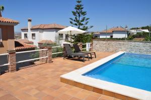 a backyard with a swimming pool and a house at La Morada de Sebas in Málaga