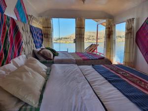two beds in a room with a view of the water at Lake View Lodge in Puno