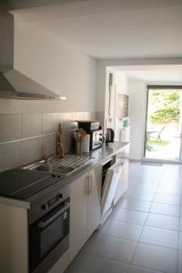 a kitchen with a sink and a stove at "Chez la Joe" in Thélonne