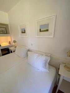1 cama blanca con almohadas blancas en una habitación en Quinta do Lago Golf en Quinta do Lago