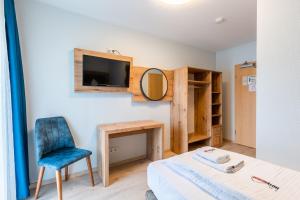 ein Schlafzimmer mit einem Bett, einem Stuhl und einem Spiegel in der Unterkunft Hotel Arena in Köln