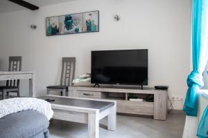a living room with a flat screen tv on a table at "Chez la Joe" in Thélonne