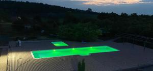 a green swimming pool with lights on a patio at Hotel Kryve Ozero in Kryve Ozero