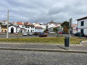 a city street with cars parked in a parking lot at Casa das Ondas in Ribeira Grande
