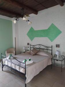 um quarto com uma cama com uma seta verde na parede em B&B La Carosella em Vatolla