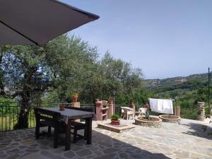 a patio with a table and chairs and an umbrella at B&B La Carosella in Vatolla