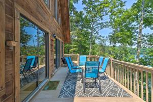 eine Terrasse mit blauen Stühlen und einem Tisch in der Unterkunft Gorgeous Cabin Retreat on Lake Lanier! in Landrum
