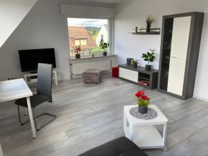 un salon avec un canapé, une table et une télévision dans l'établissement Helle moderne Ferienwohnung, Nähe Koblenz am Rhein, à Weitersburg