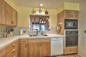 a kitchen with wooden cabinets and a sink and a microwave at Sedona Home with Golf Course View and Pool Access! in Sedona