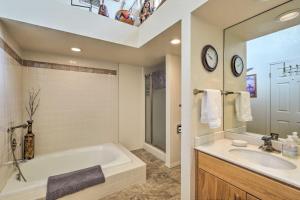 a bathroom with a tub and a sink and a mirror at Sedona Home with Golf Course View and Pool Access! in Sedona