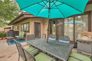 a table and chairs with an umbrella on a patio at Sedona Home with Golf Course View and Pool Access! in Sedona