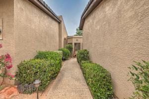 a walkway next to a building with green bushes at Sedona Home with Golf Course View and Pool Access! in Sedona