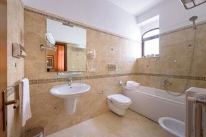 a bathroom with a sink and a toilet and a bath tub at Leone de Castris Wine Hotel in Salice Salentino