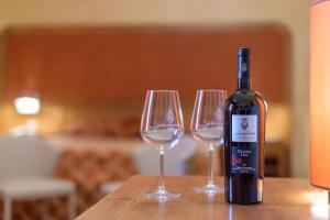 a bottle of wine sitting next to two wine glasses at Leone de Castris Wine Hotel in Salice Salentino