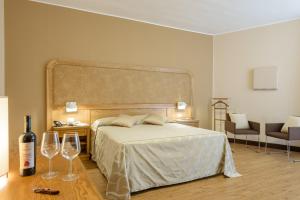 a bedroom with a bed and two wine glasses at Leone de Castris Wine Hotel in Salice Salentino