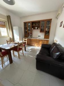 a living room with a black couch and a table at Casa Vacanze I Canarini in Città Giardino