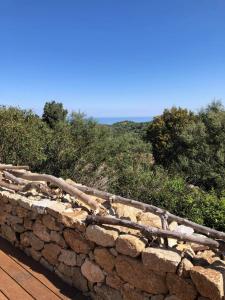 a stone wall with a log on top of it at 1722 Chambres de Charme in Ville-di-Paraso