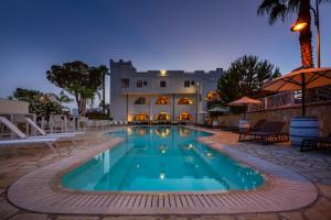 a swimming pool in front of a building at night at Leone de Castris Wine Hotel in Salice Salentino +73 photos