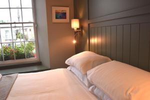 2 camas en un dormitorio con ventana en Crown Inn, en Penzance