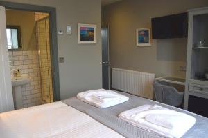 Un dormitorio con una cama con dos toallas encima. en Crown Inn, en Penzance