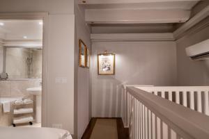 a white bathroom with a sink and a staircase at The Xara Palace Relais & Chateaux in Mdina