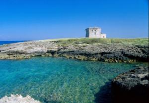 a lighthouse on top of an island in the ocean at Casa Mediterranea Jacuzzi riscaldata con Caminetto in Specchiolla