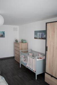 a baby room with a crib and a dresser at "Chez la Joe" in Thélonne