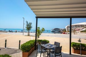 a patio with a table and chairs next to a beach at Hotel Kristal in Durrës