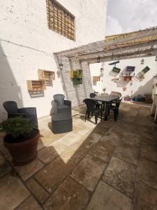 un patio con tavolo e sedie in un edificio di B&B La volta di Fabio De Marco e Simona Saracino a San Pietro Vernotico