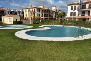 two pools in a yard with buildings in the background at Playa, Golf y Montaña. Dos países, un lugar único. in Huelva