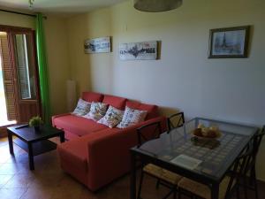 a living room with a red couch and a table at Playa, Golf y Montaña. Dos países, un lugar único. in Huelva