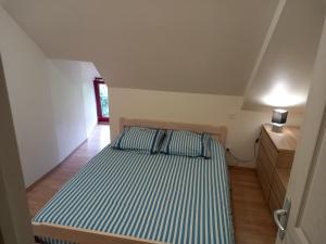 - une chambre avec un lit à rayures bleues et blanches dans l'établissement Chez Jojo à St fraimbault, à Saint-Fraimbault-de-Prières