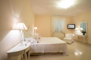 um quarto com uma cama, um candeeiro e uma cadeira em Tenuta Belvedere - Relais du Charme em Alezio
