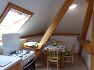 a kitchen with a stove and a table with chairs at Hold-on apartman in Gyula