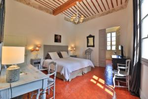 a bedroom with a bed and a table and chairs at Le Jardin de Mazan in Mazan