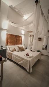 a bedroom with a large bed with white sheets at Borgo San Giovanni Luxury in Francavilla Fontana