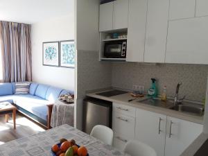 cocina y sala de estar con sofá y mesa en MIRAMAR ATTICO, en Morro del Jable