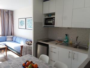 a kitchen and living room with a couch and a table at MIRAMAR ATTICO in Morro del Jable