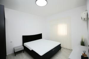 a bedroom with a white bed with a black headboard at City center luxury apartment in Netanya in Netanya