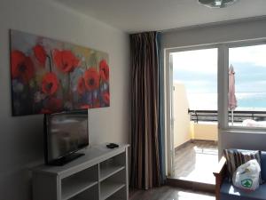 a living room with a flat screen tv and a window at MIRAMAR ATTICO in Morro del Jable