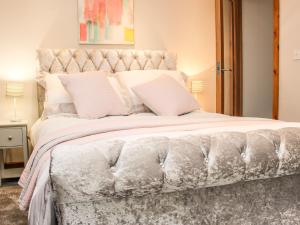 sypialnia z dużym łóżkiem z białą pościelą i poduszkami w obiekcie Sunnyside w mieście Leominster