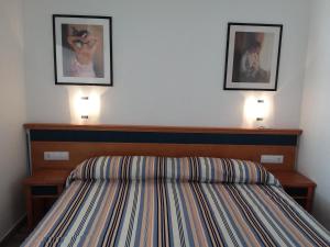 a bedroom with a bed with two pictures on the wall at MIRAMAR ATTICO in Morro del Jable +21 photos