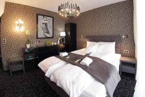 a hotel room with a bed and a chandelier at Alex Palace in Dziwnów