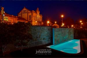 a swimming pool in front of a brick wall at night at Casa Melo Alvim - by Unlock Hotels in Viana do Castelo +90 photos