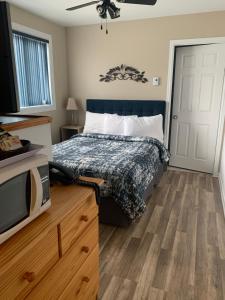 a bedroom with a bed and a dresser at Motel Des Cascades in Baie-Saint-Paul