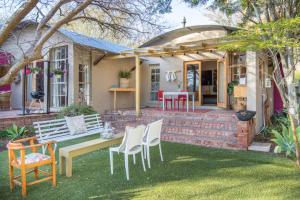 a house with a table and chairs in the yard at Aasvoelkrans Guest Farm in Montagu