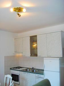 una cocina con armarios blancos y fregadero en Apartments Nikolas, en Vodice