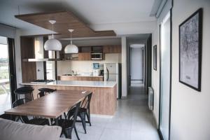 a kitchen and dining room with a wooden table and chairs at Del Cerro Alquiler Temporario in Tandil