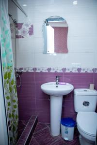 een badkamer met een wastafel, een toilet en een spiegel bij DUPLEX in Tbilisi City +37 foto's